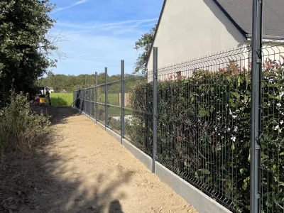 Clôture rigide posée le long d’un jardin résidentiel