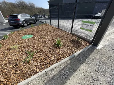 Aménagement paysager avec paillage bois près d’un parking