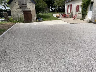 Cour en gravier stabilisé devant maison en pierre