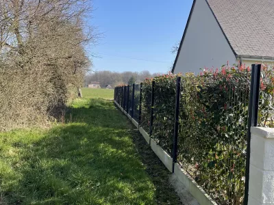 Clôture rigide avec haie végétale le long d’un jardin
