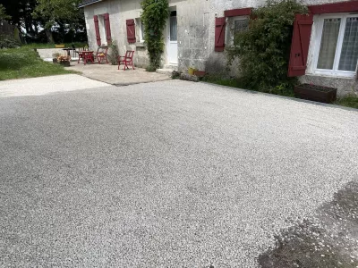Cour en gravier stabilisé devant une maison avec terrasse